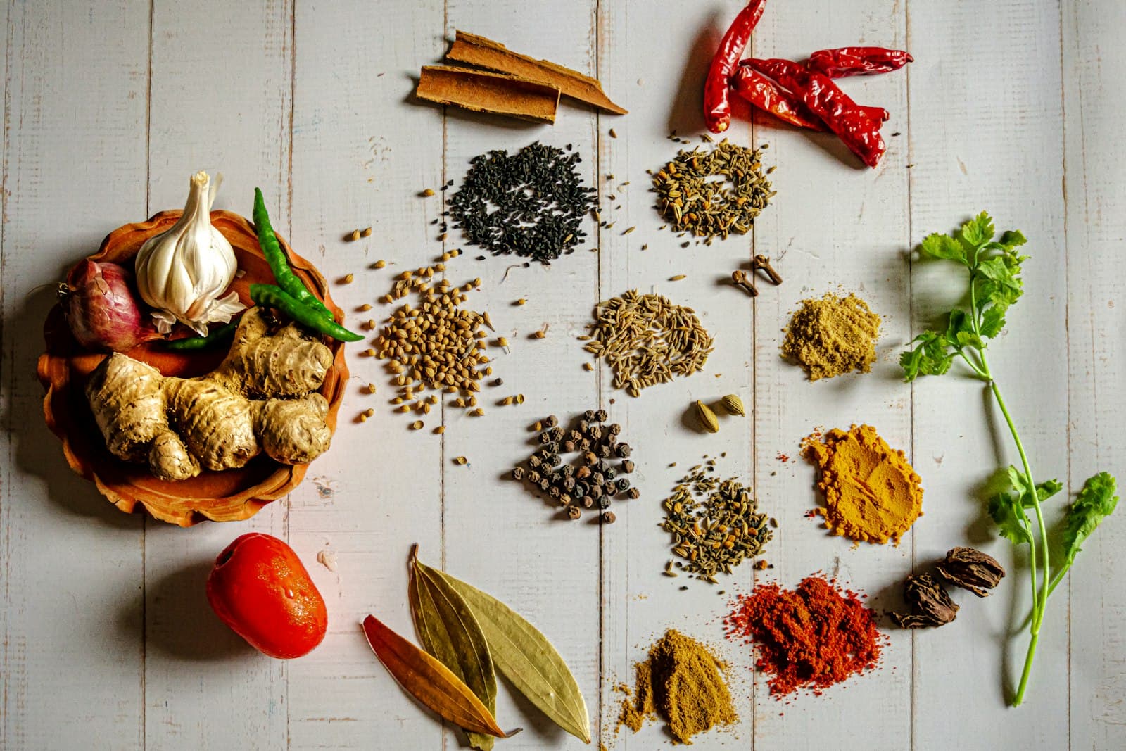 Whole spices and aromatics laid out for selection